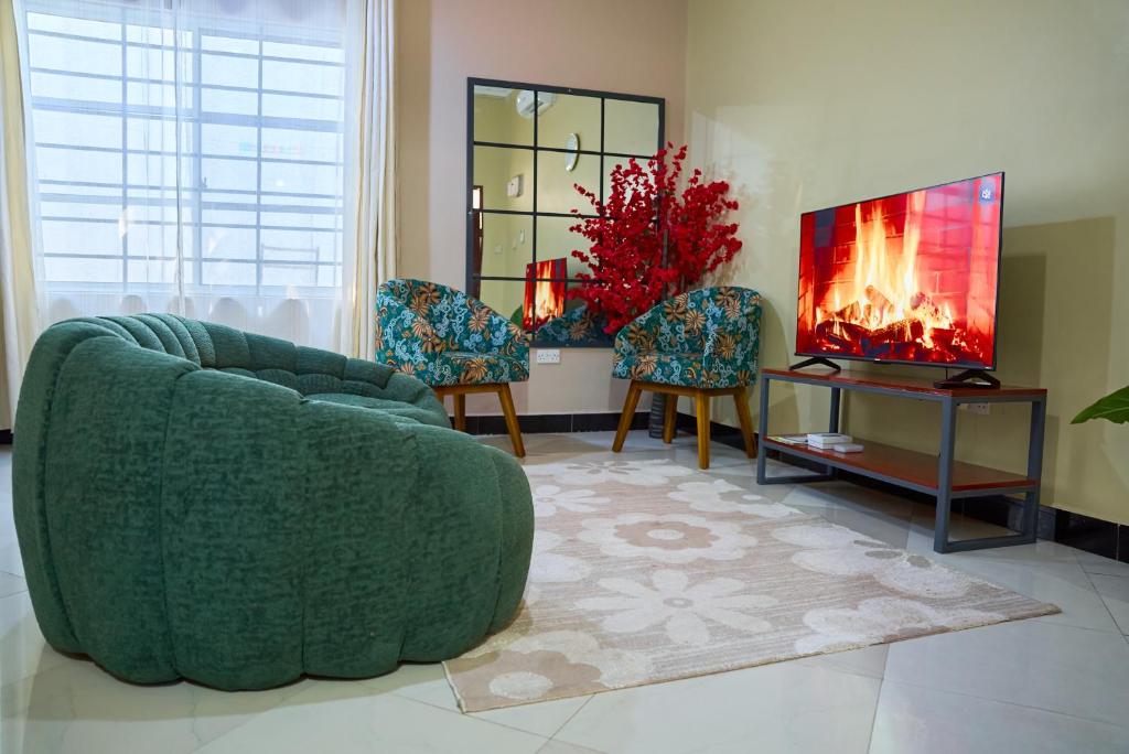 a living room with a green couch and a fireplace at Heaven Homes - Salama Stay in Dar es Salaam