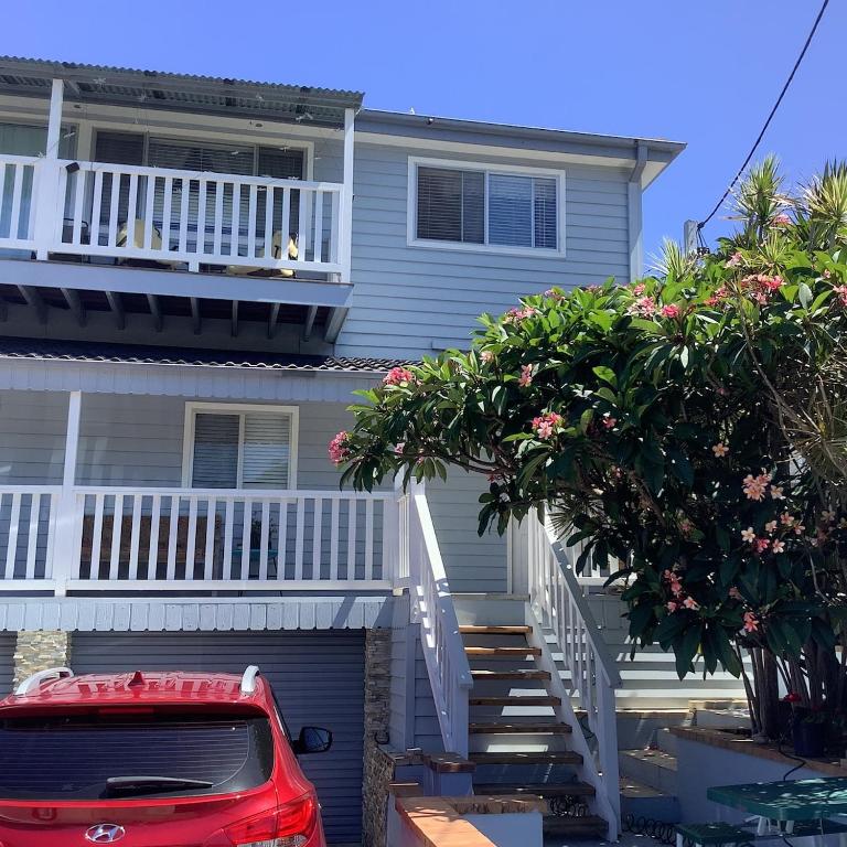 a red car parked in front of a house at Holiday house in Nelson Bay