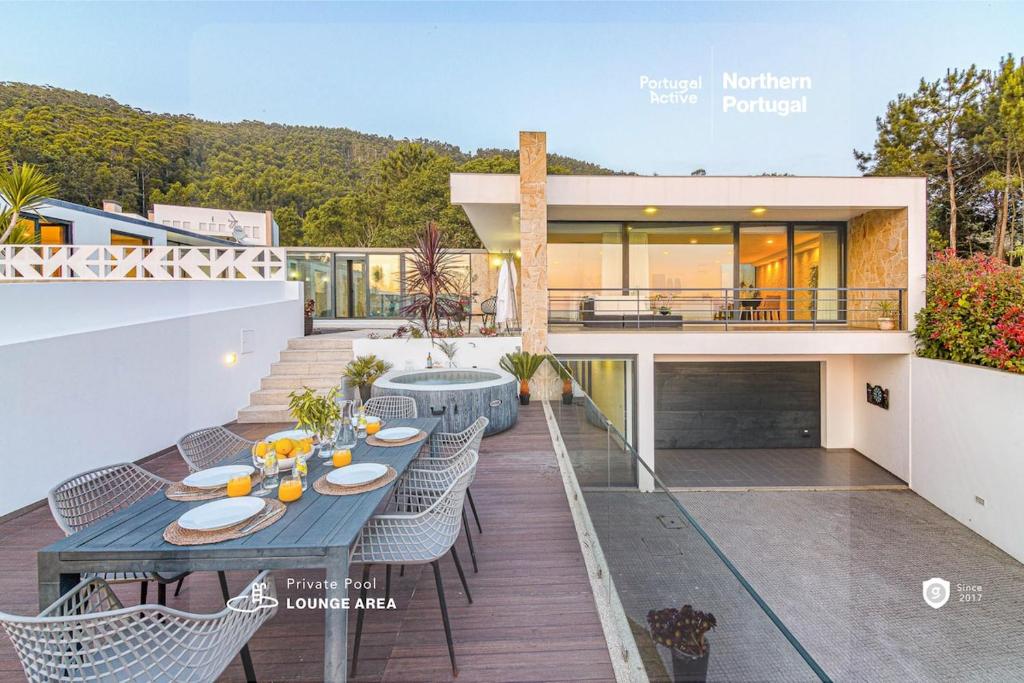 una casa con un tavolo e sedie blu su un balcone di Portugal Active Sunset Beach Lodge a Paço