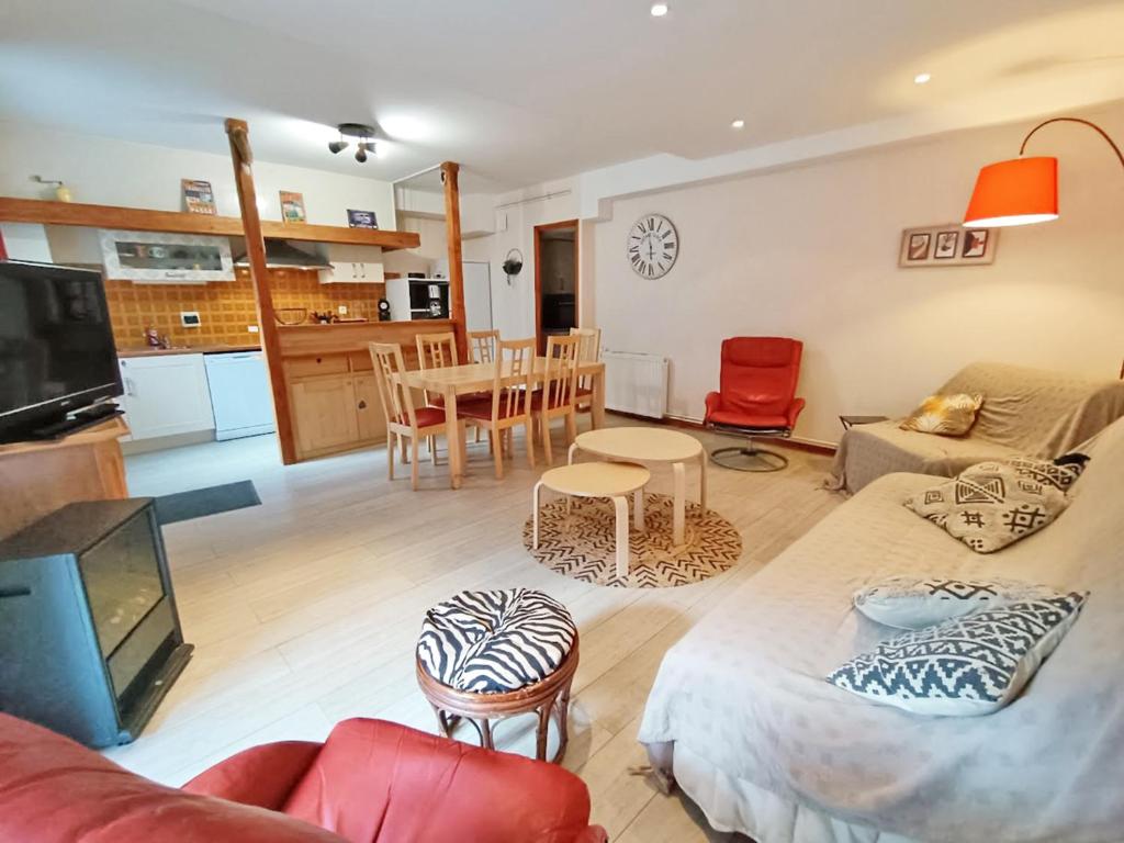 ein Wohnzimmer mit Sofa und Tisch in der Unterkunft Le Saint M, T3, wifi, parking, jardin, Saint Mamet in Saint-Mamet