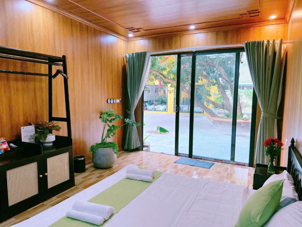 een slaapkamer met een groot bed en een groot raam bij For You Ninh Binh Boutique in Ninh Binh