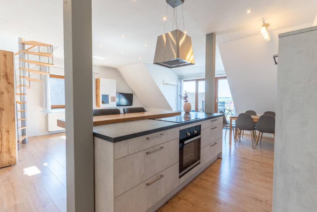 a kitchen with white cabinets and a stove top oven at Aparthotel Hohenfels in Hohenfels
