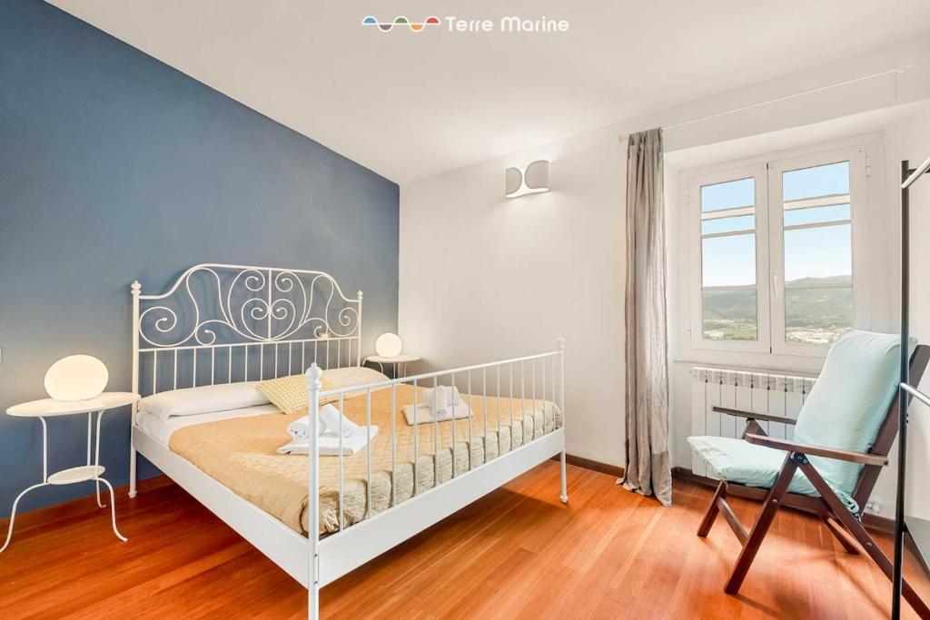 una camera da letto con un letto, una sedia e una finestra di Corte del Poeta, TerreMarine a Vezzano Ligure