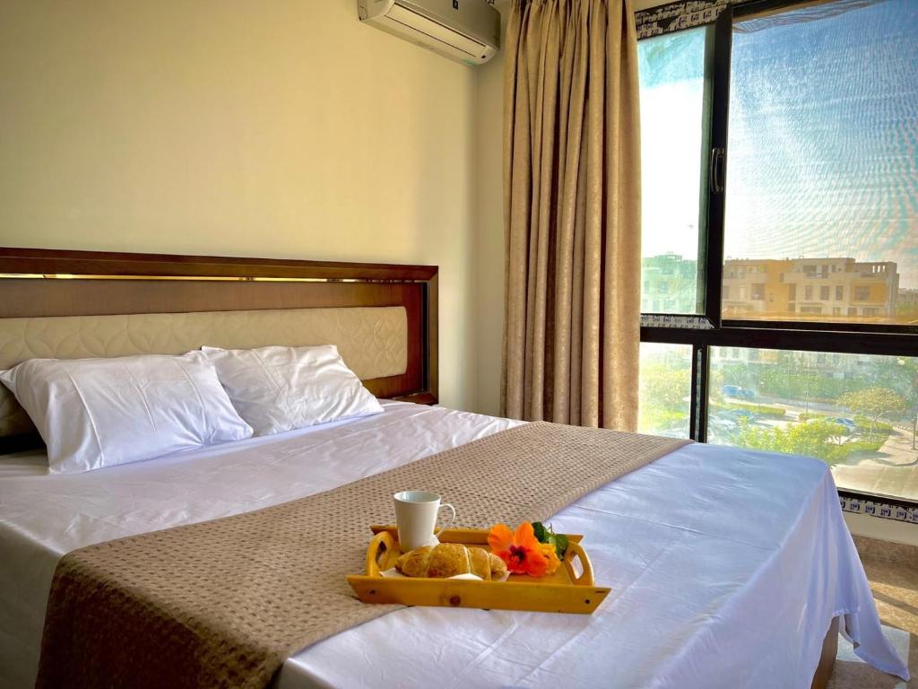 a hotel room with a bed with a tray with toys on it at Luxury Stylish Modern 2 Beds Hotel Apartment - East Town Compound - Sodic -New Cairo - Cairo - Egypt in Cairo