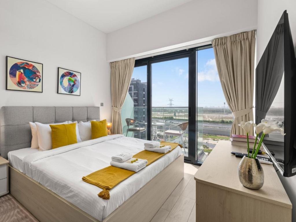 a bedroom with a large bed and a large window at The Comfort Cove Studio in Azizi Riviera 44 in Dubai