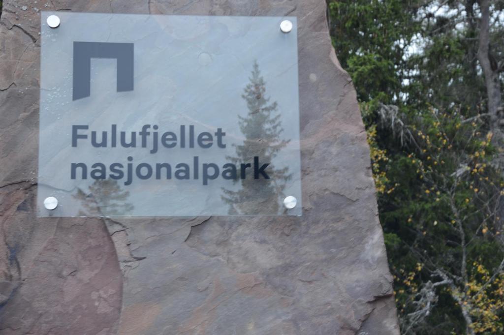 a sign for a park on a rock wall at Fulufjellet nationalpark Lodge - Fulufjellets national parks - This is the place where Norway and Sweden meet in a large protected area in Ljørdalen
