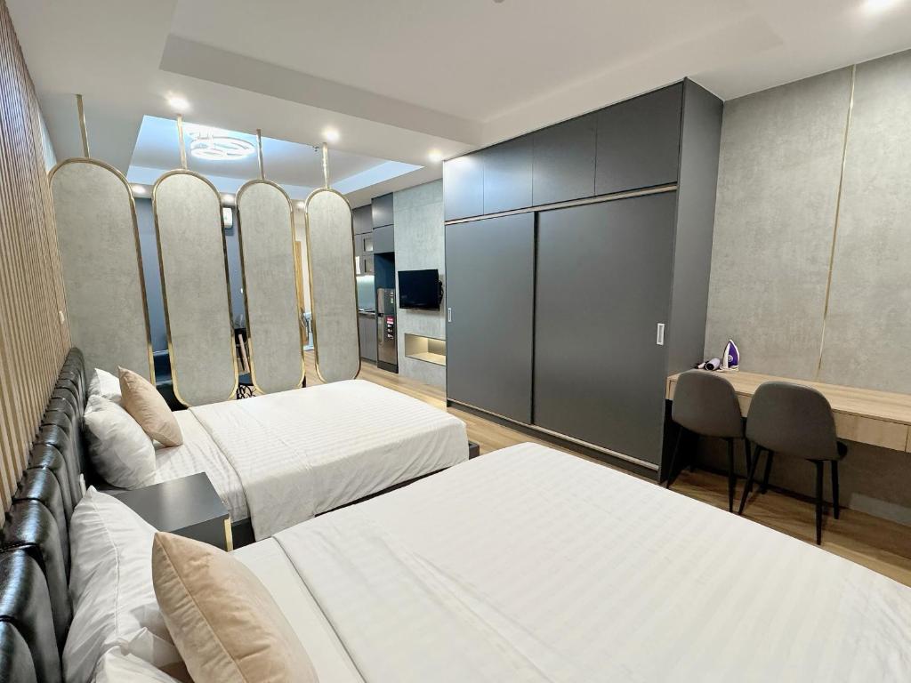 a hotel room with two beds and a desk at TMS Quy Nhơn - Hupasearest Apartment SeaView in Quy Nhon