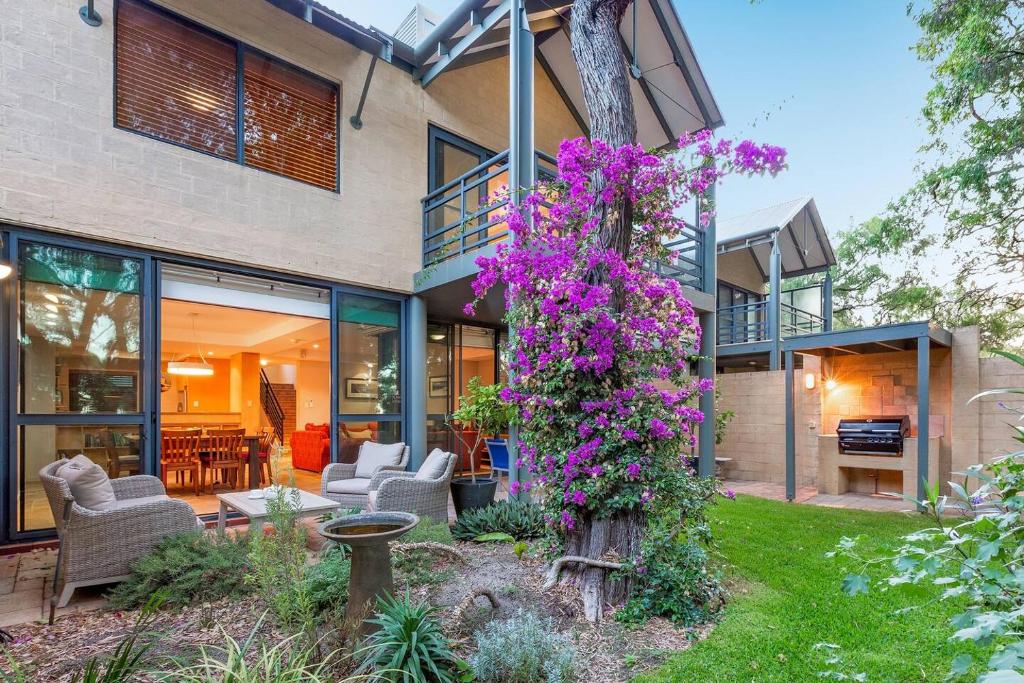 a house with purple flowers on the side of it at Sea Vista - Beachside Resort-style Bliss in Broadwater