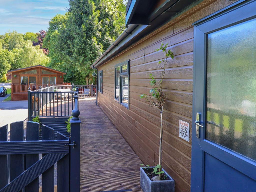 a wooden walkway next to a building with a blue door at Evermore Lodge in Windermere