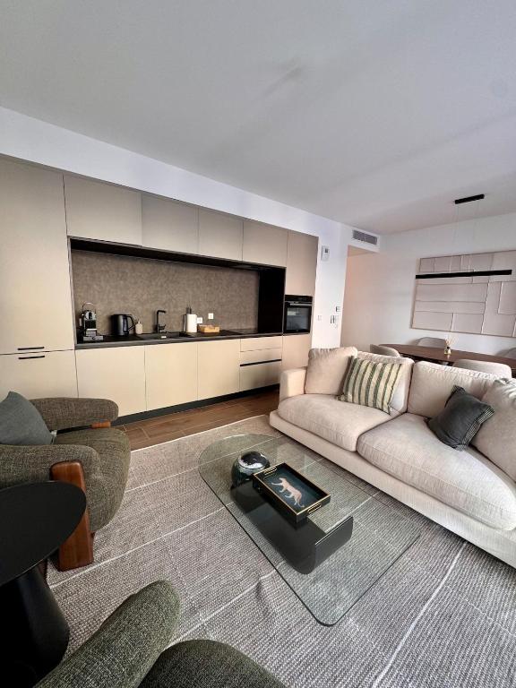 a living room with a couch and a table at Stylish 2BR Monaco Border Flat, Terrace & Parking in Beausoleil