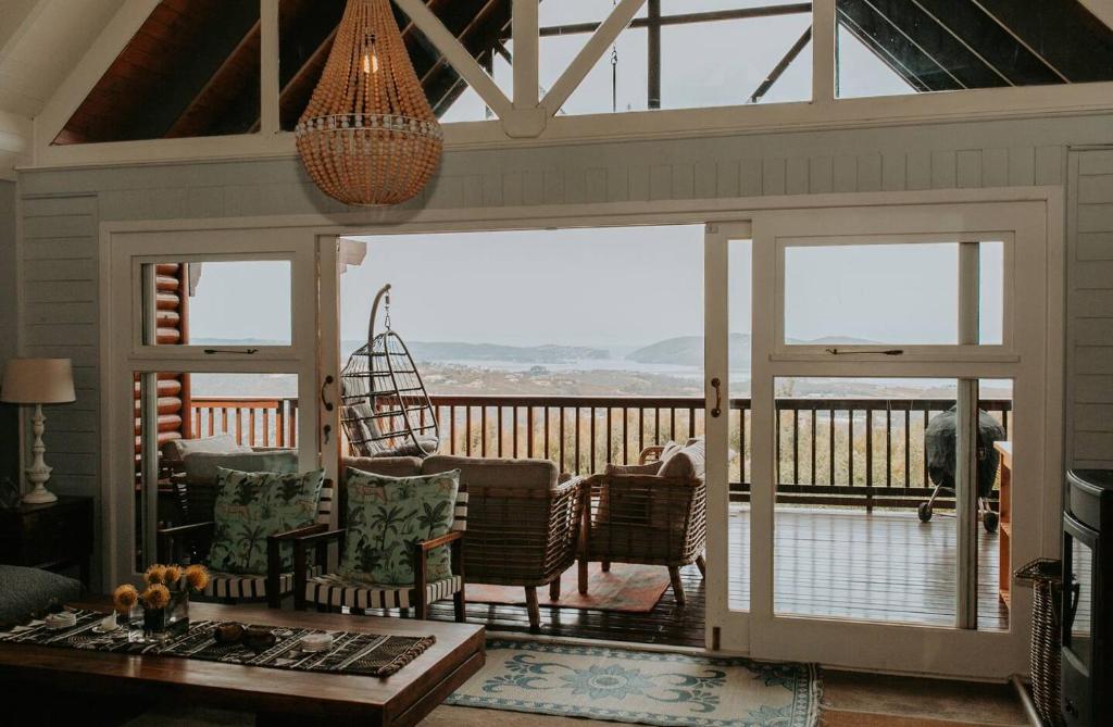 a living room with a screened in porch with sliding glass doors at Forest Hideaway In Knysnas Phantom Pass in Knysna