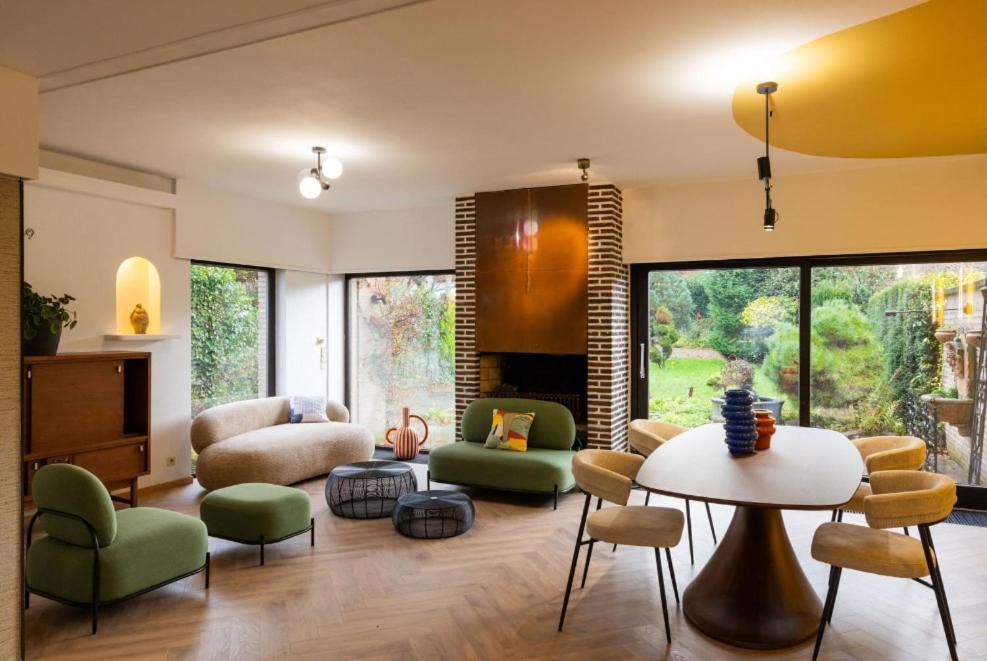 un soggiorno con tavolo e sedie di Maison modernisée au caractère 70ies a Herstal