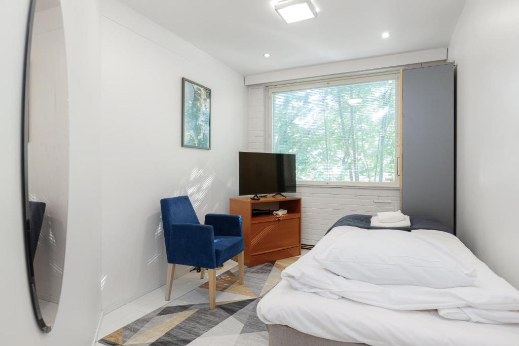 una camera con letto, TV e sedia di Kotimaailma Rooms - Ankkuri 1hh a Kotka