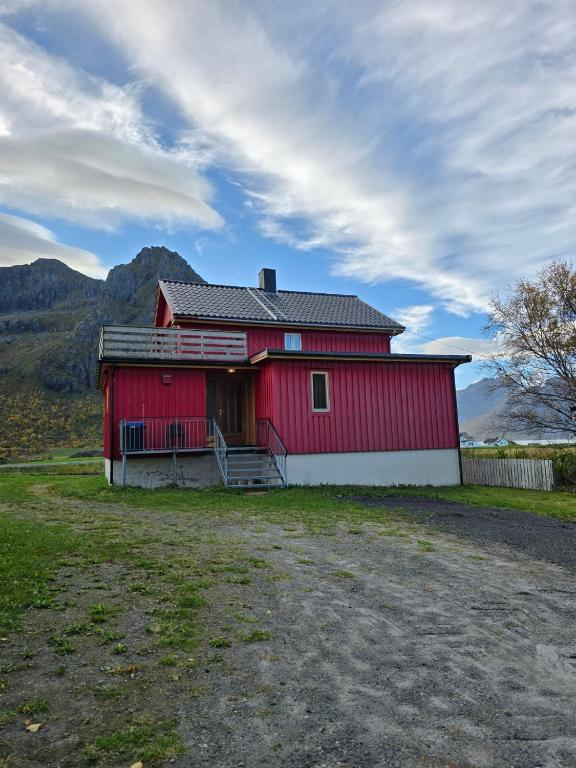 a red barn with mountains in the background at Vareid Panorama Lofoten Lysvollhuset in Vareid