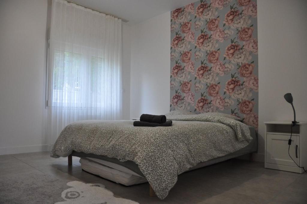 Appartement avec Jardin في لا فيرْت-سو-جوار: غرفة نوم بسرير وبطانية ونافذة