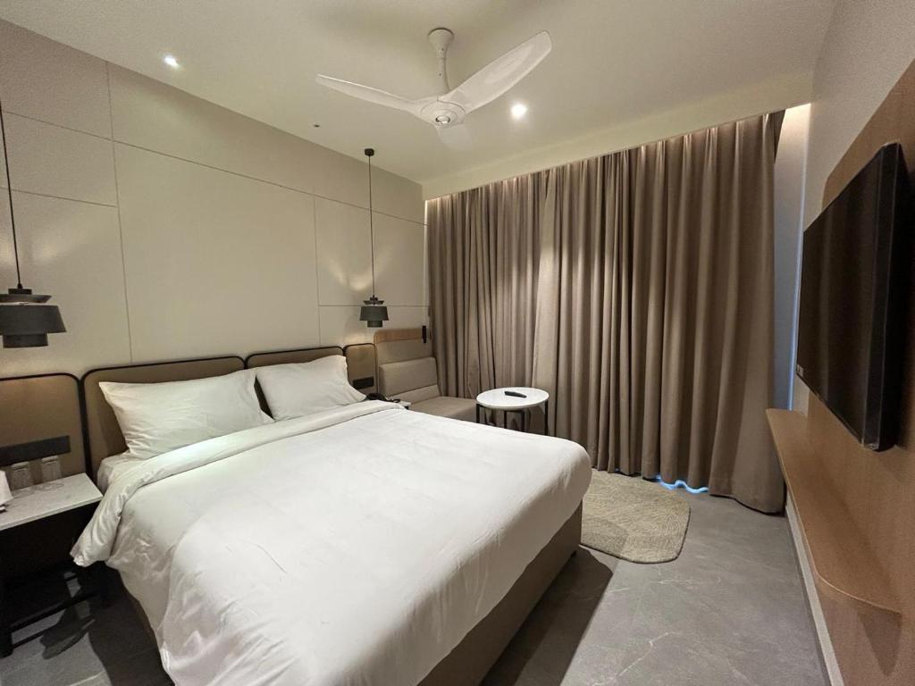 a bedroom with a large white bed and a window at 7 Apple Hotel Vizag, Visakhapatnam in Dāpuri