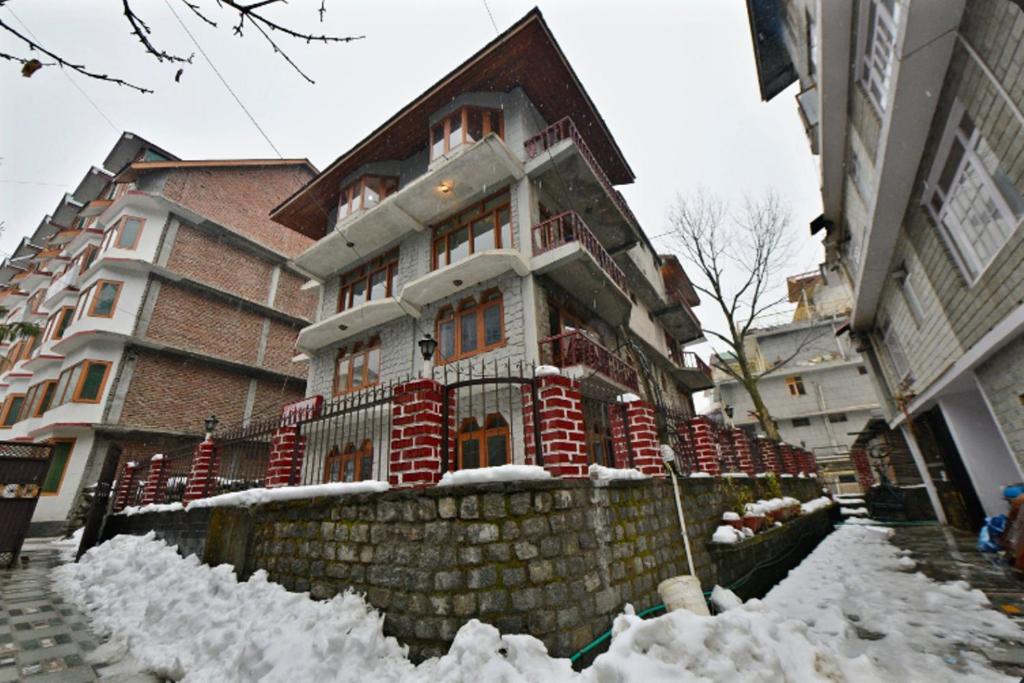 a house is covered in snow on a street at Potala Hotel in Jāmb