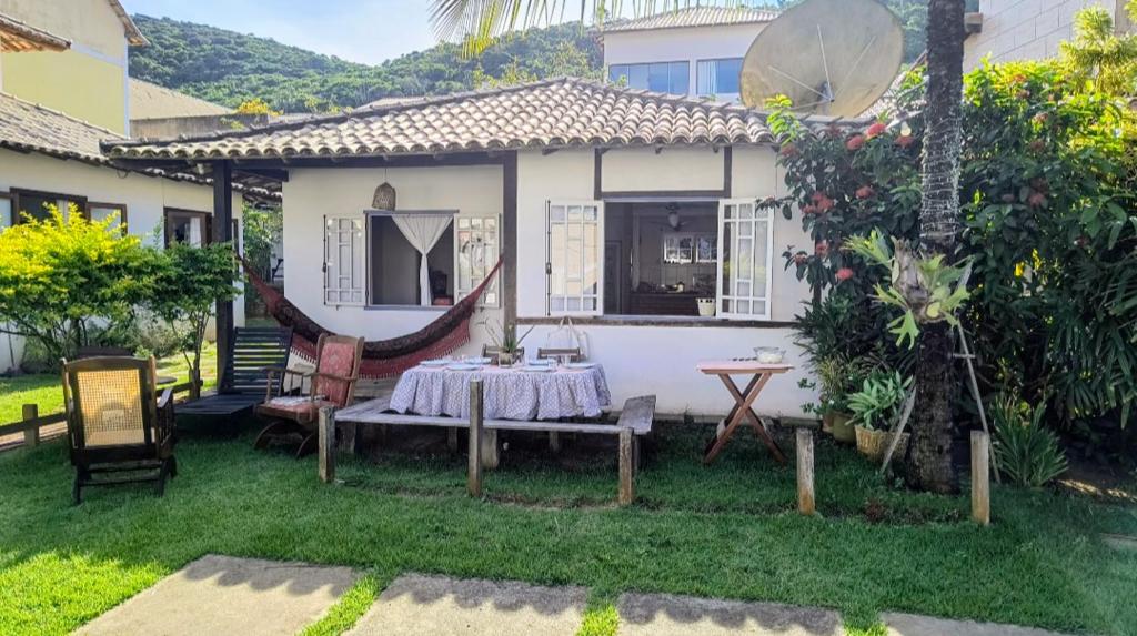 a table in the backyard of a house at Casinhas do Peró Refúgio com Jardim e WiFi Rápido in Cabo Frio