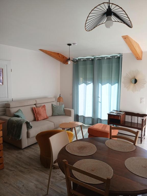 a living room with a couch and a table at La petite maison in Gourdon-en-quercy
