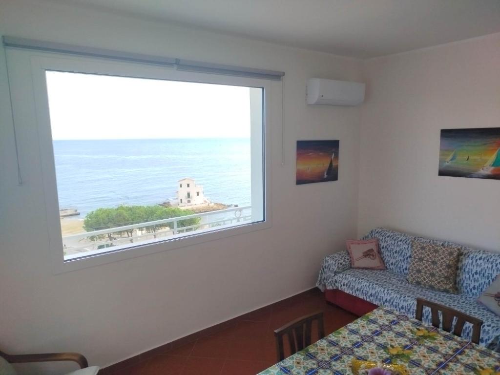 a living room with a large window and a couch at Bellavista in Santa Flavia