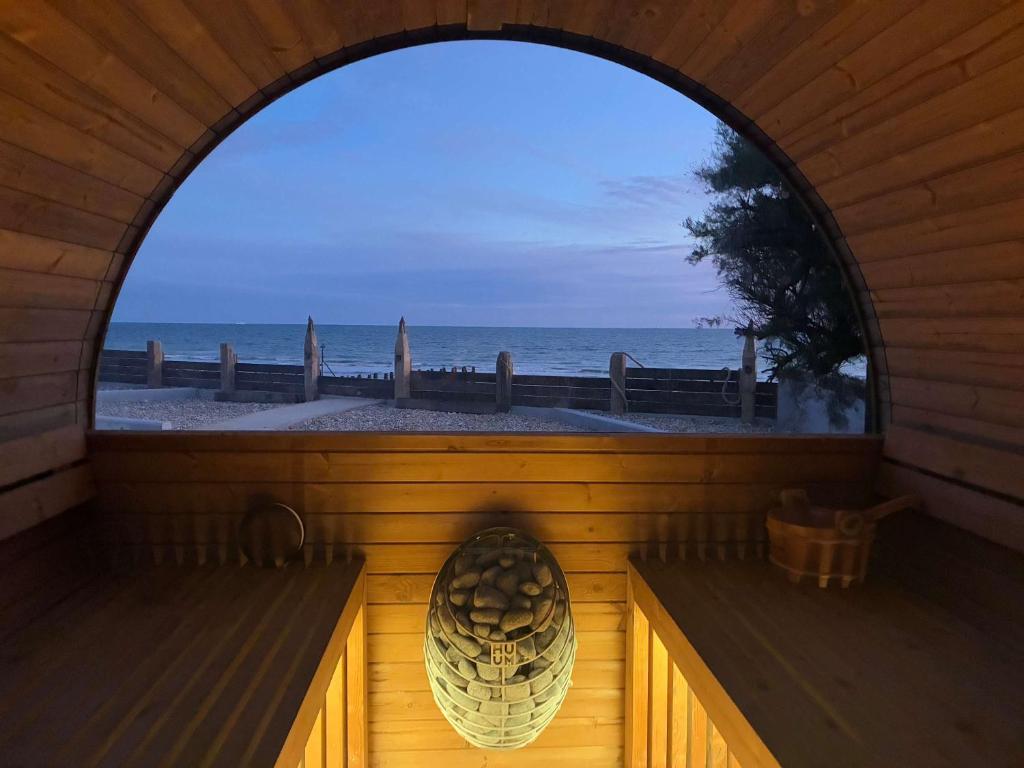 Cette chambre dispose d'une fenêtre donnant sur la plage. dans l'établissement Luxury Seafront Family Home - Indoor Pool, à Earnley