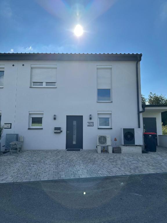 una casa blanca con muchas ventanas y una entrada en Gemütliche Doppelhaushälfte mit Garten, Terrasse Ruhige Lage in Hobersdorf, 