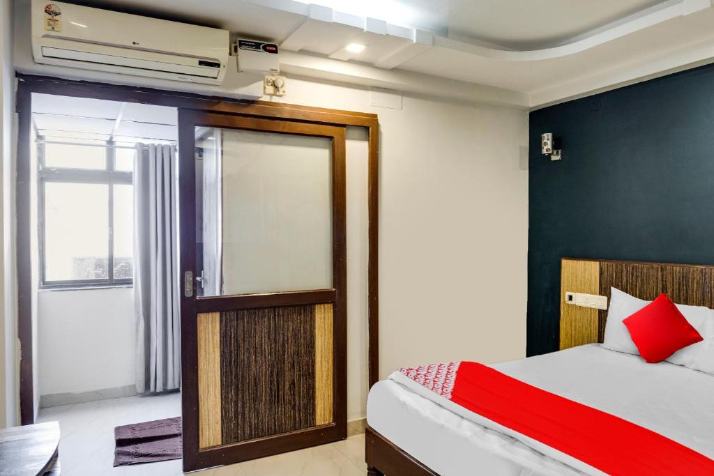 Un dormitorio con una cama y una puerta corrediza de vidrio. en Hotel O Sea View Inn, en Chennai