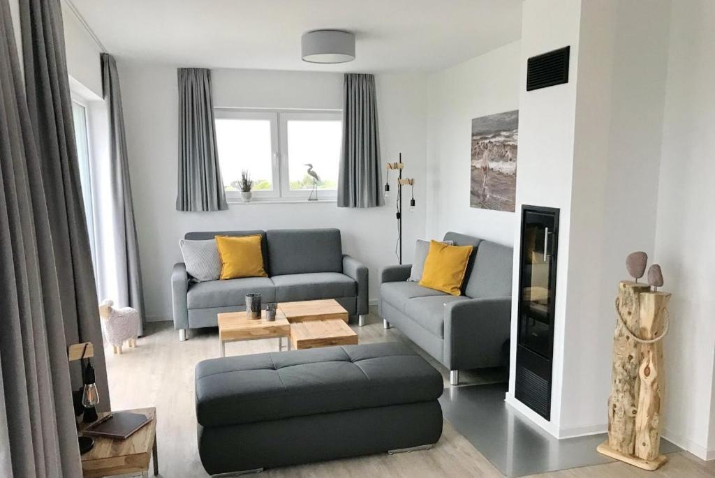 ein Wohnzimmer mit Sofa und Tisch in der Unterkunft NordseeResort Friesland Ferienhäuser NordseeResort Friesland 48-6-n in Schillig