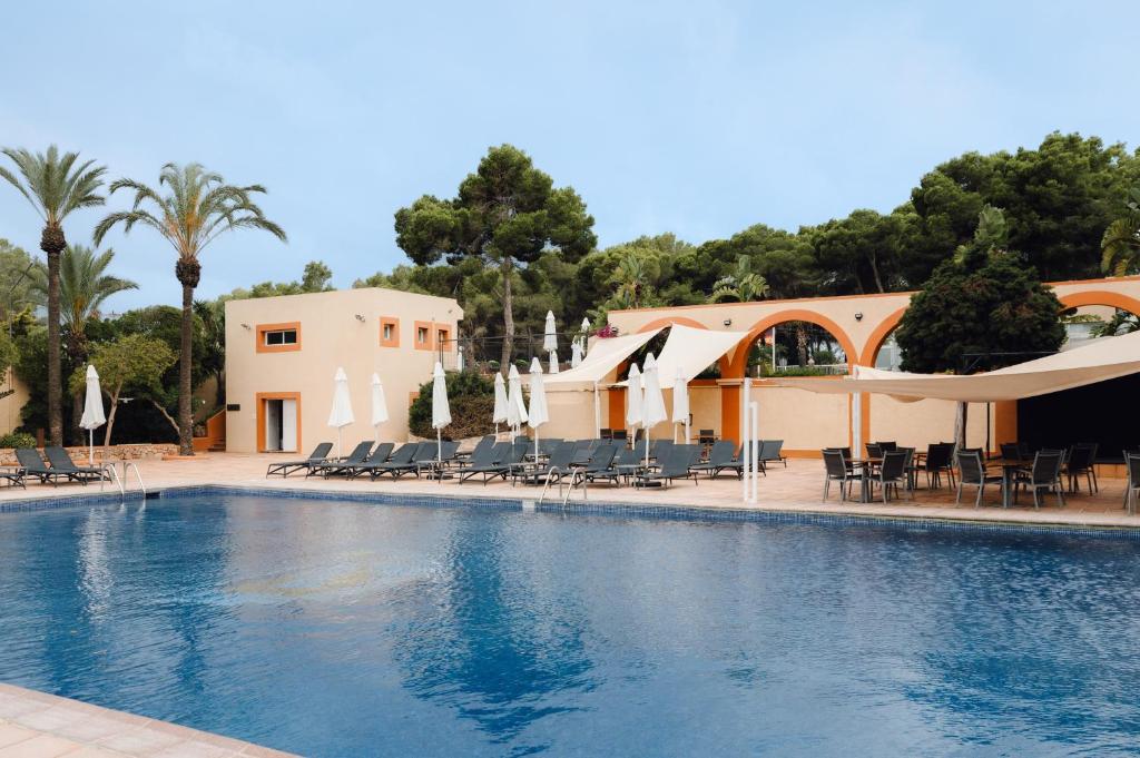 a large swimming pool with chairs and a building at Moon Dreams Atlantic in Es Cana