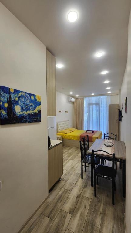 a room with a dining table and a bedroom at Ande Tower, Batumi in Minda