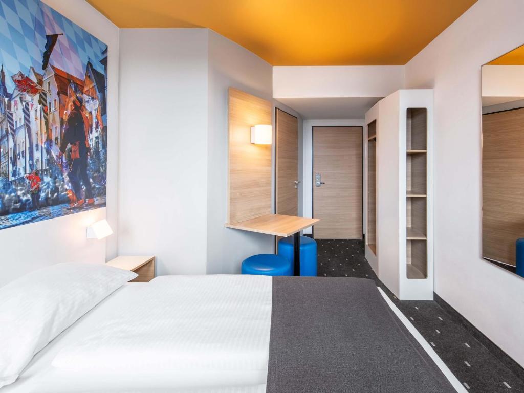 una habitación de hotel con una cama y un escritorio en B&amp;B Hotel Landshut, en Landshut
