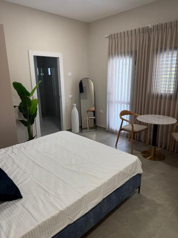 a bedroom with a bed and a table and chairs at Sailors Hotel in Ashdod
