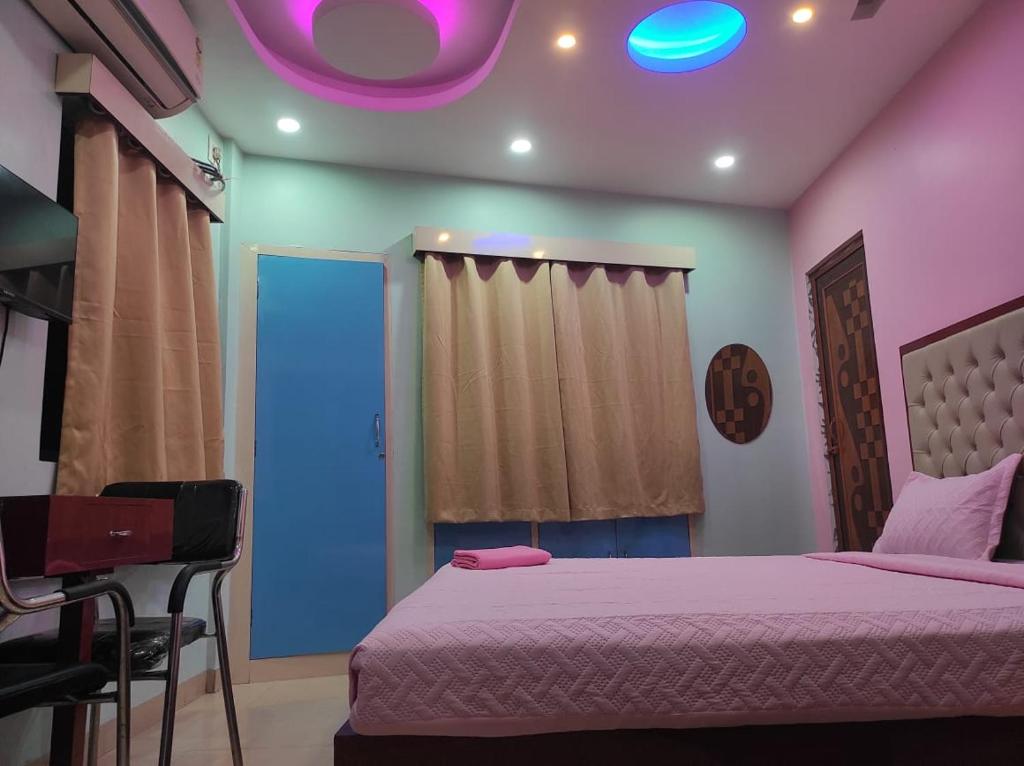 a bedroom with a bed and a purple light at Gunjan guest house near sskm hospital in Kolkata