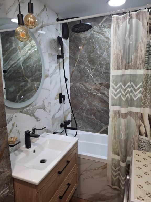 a bathroom with a sink and a shower at Уютная 2-х комнатная квартира in Rudny