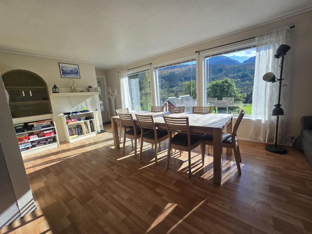 a dining room with a table and chairs and a large window at Brendefur Panorama in Lii