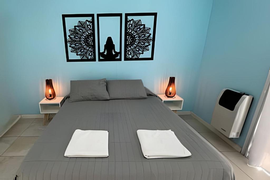 a bedroom with a bed with two lamps and two mirrors at Hermoso depto, mts parque, AA y Parking in Villa Marini
