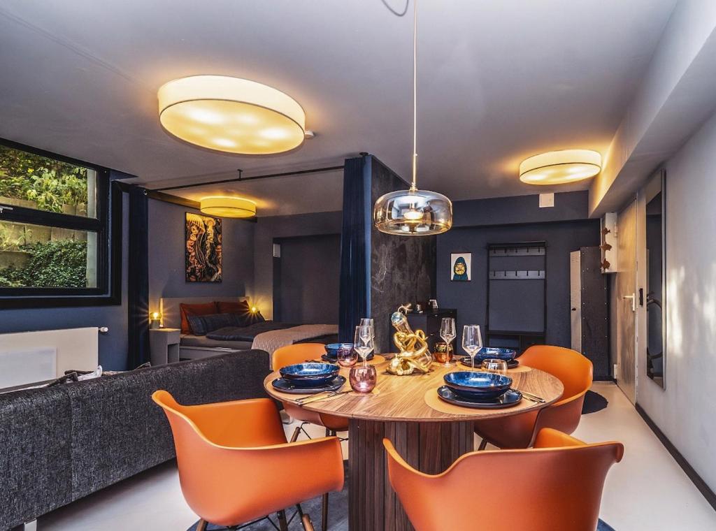 a dining room with a table and orange chairs at Wunderschönes Loft-Apartment im grünen Hamburg in Hamburg