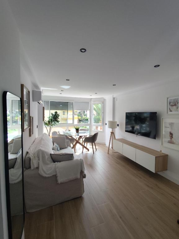 a white living room with a couch and a tv at Refugio del Mar Primera linea a estrenar in Algarrobo-Costa