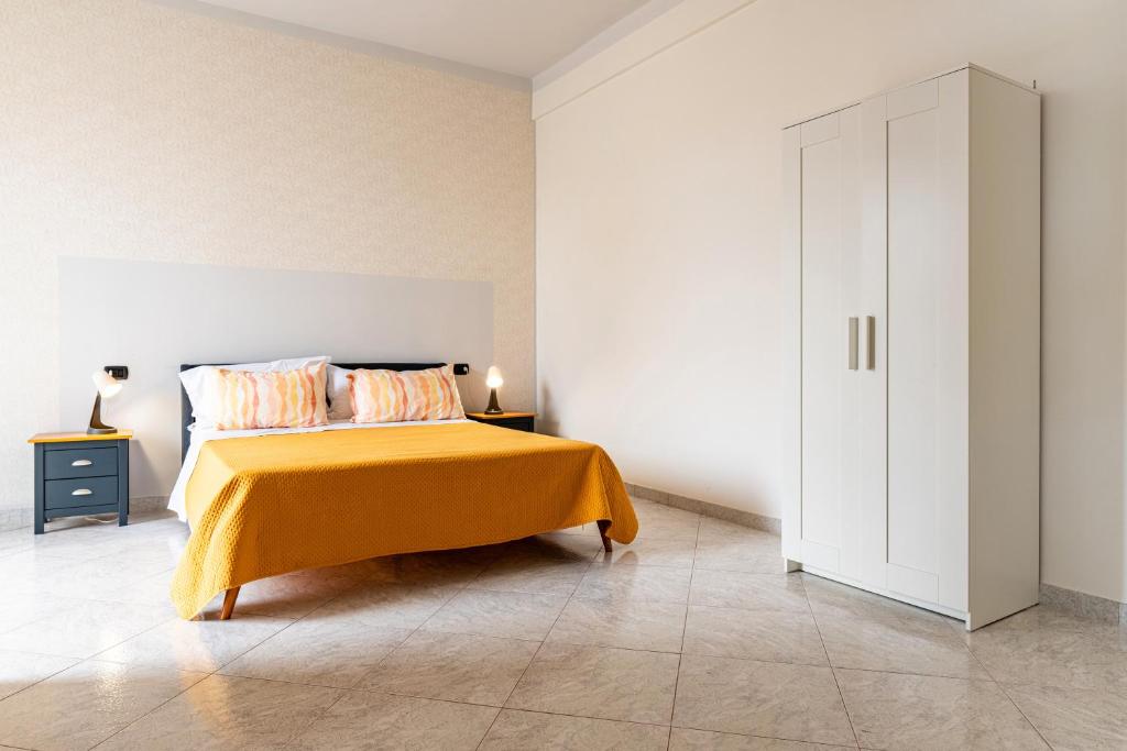 a bedroom with a bed with a yellow blanket and a cabinet at Civico 23 in Matera