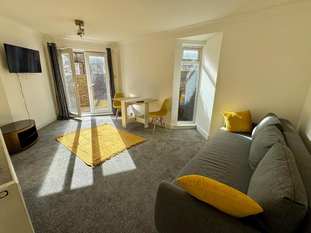 a living room with a couch and a table at Comfortable, London 1 Bed Garden in London