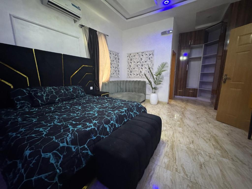 Un dormitorio con una cama grande y un sofá. en Effixzzy villa, en Lekki