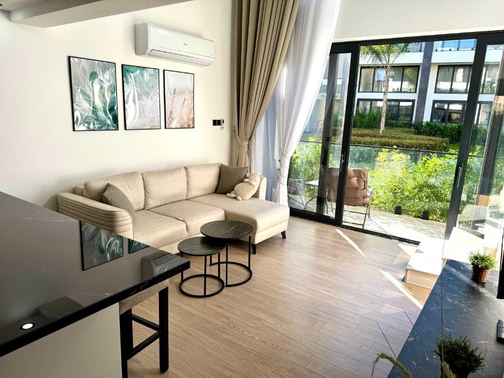 a living room with a couch and a table at Luxurious 1 bedroom duplex apartment in Palmera Resort in Ayios Yeoryios