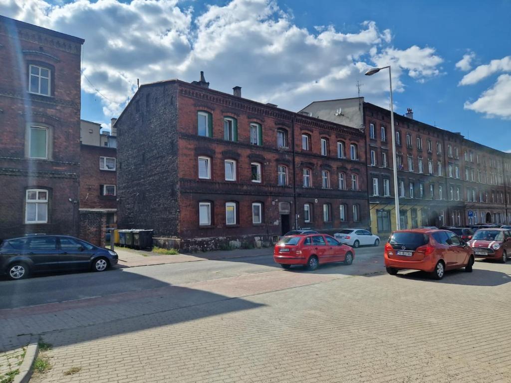 a group of cars parked in front of a building at Apartamenty Retro Loft in Chorzów