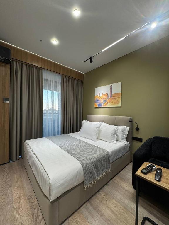a bedroom with a large bed and a couch at Deluxe Studio NRG U-Tower in Tashkent