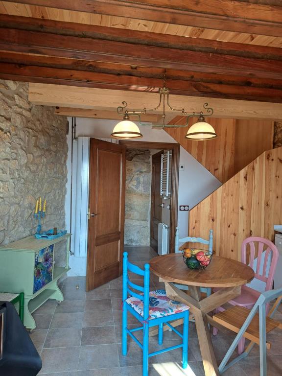 a kitchen and dining room with a wooden table and chairs at Casa Rural Haiku in Bojar