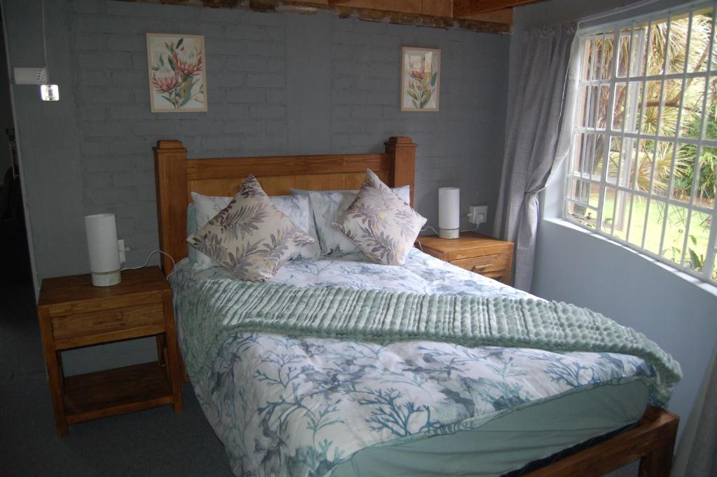 1 dormitorio con 1 cama, 2 mesitas de noche y ventana en Nita's Air Bed & Breakfast & self catering, en Crocodile Valley Estates