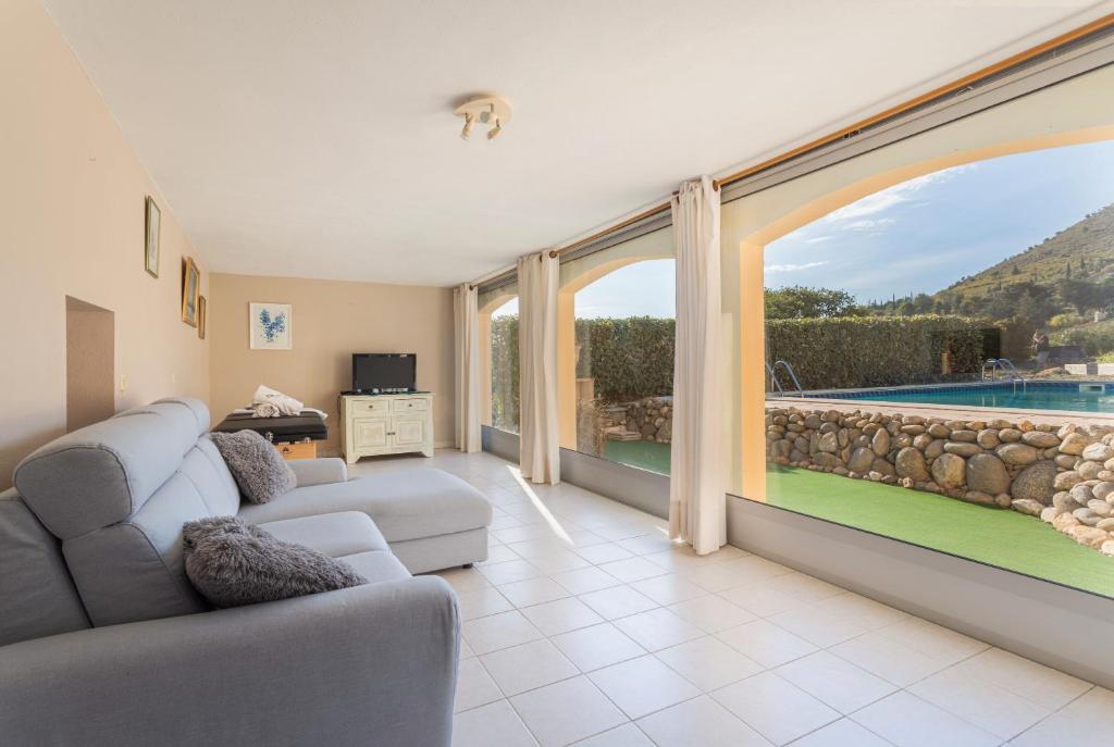 un soggiorno con una grande finestra e una piscina di Gîte dels Ocells a Camélas