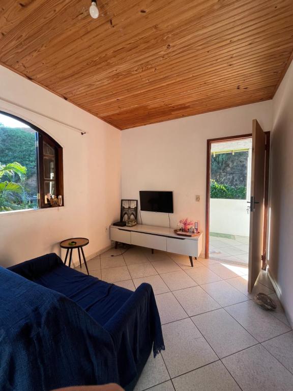 a bedroom with a bed and a tv in a room at Casa no sana in Macaé