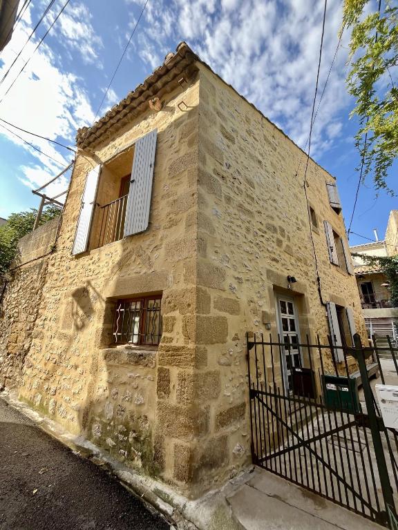 an old stone house with a fence in front of it at Beautiful Village Silk House, with terrace in Collias