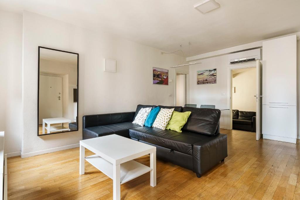a living room with a black leather couch and a table at CDT Duomo in Florence